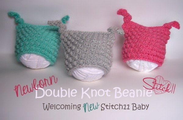 three double knot newborn beanies in colors blue, gray and pink displayed on balls of yarn to show size reference. 