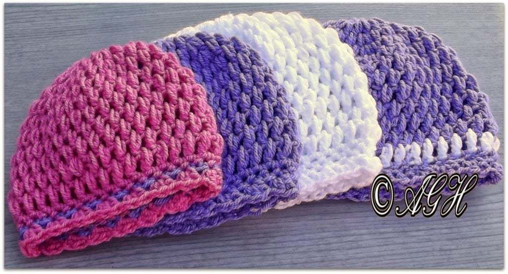 Four puff stitch crochet newborn size beanies. One white beanie, one pink beanie and two purple beanies