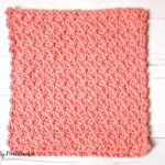 Coral colored crochet dishcloth.