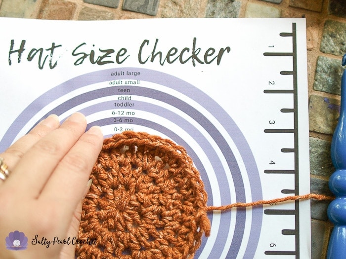 Using the Crochet Hat Size Checker Printable to determine the size this crochet hat will be.