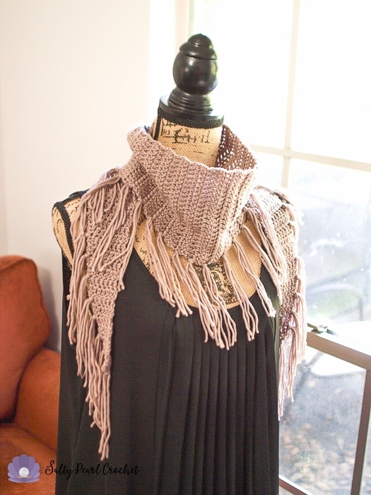 Angled view of the free crochet triangle scarf to show the fringe.