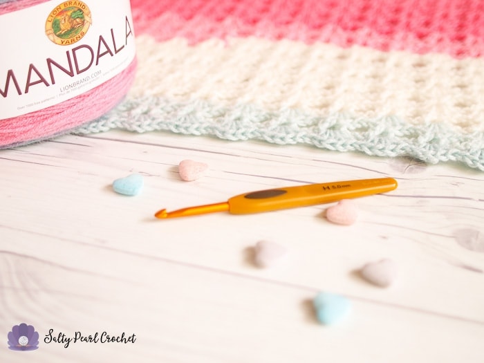 A Clover Soft Touch Crochet Hook with a candy colored crochet project.