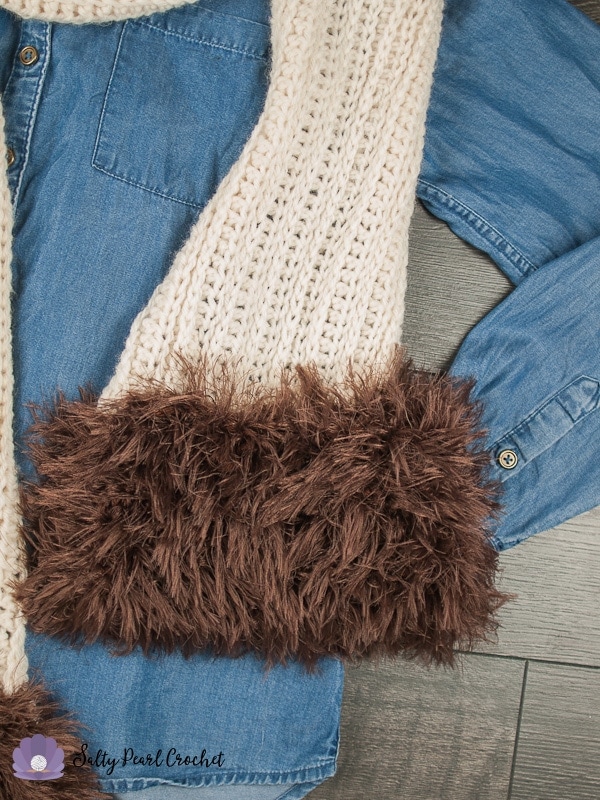 Close up of knit scarf with focus on the brown faux fur muff
