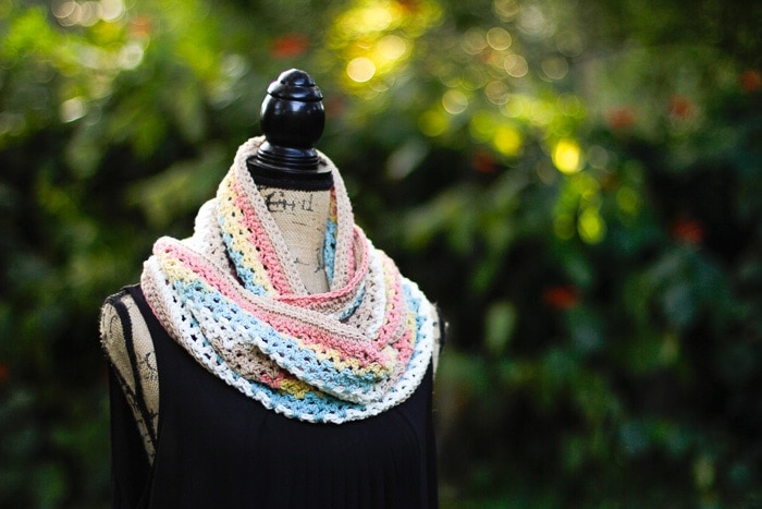 Pastel rainbow crochet scarf doubled up to show another way to wear it on a mannequin with a black dress on. 