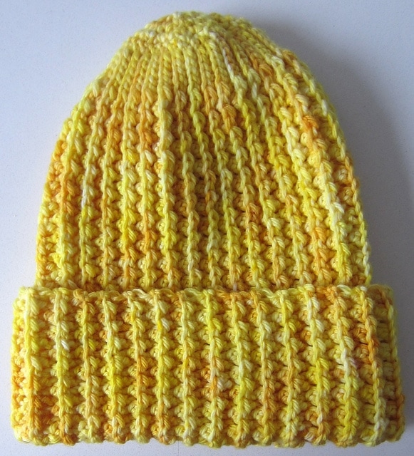 Yellow ribbed crochet rib watchman's cap in white background. 