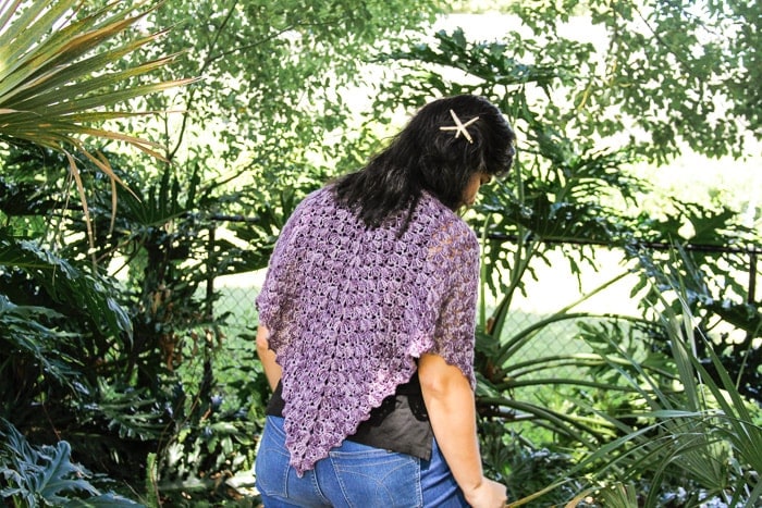 Woman wearing a purple crocheted shawl.