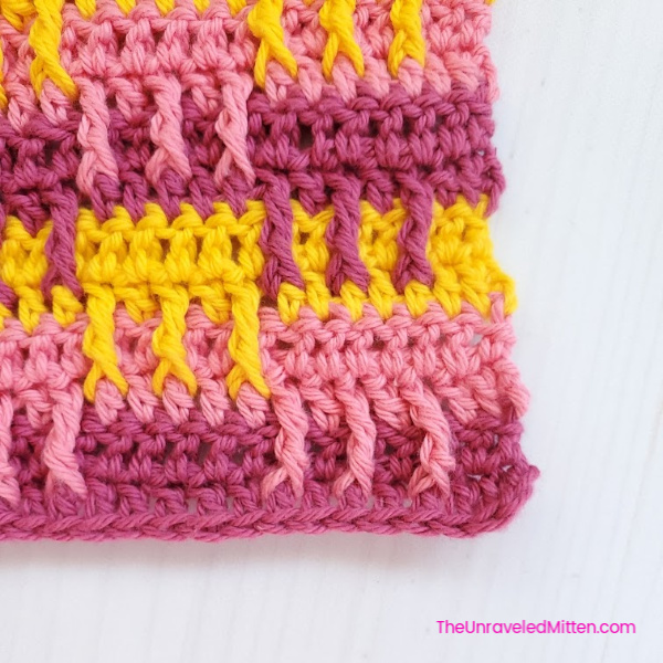 A pretty textured crochet dishcloth pattern in pink and yellow stripes