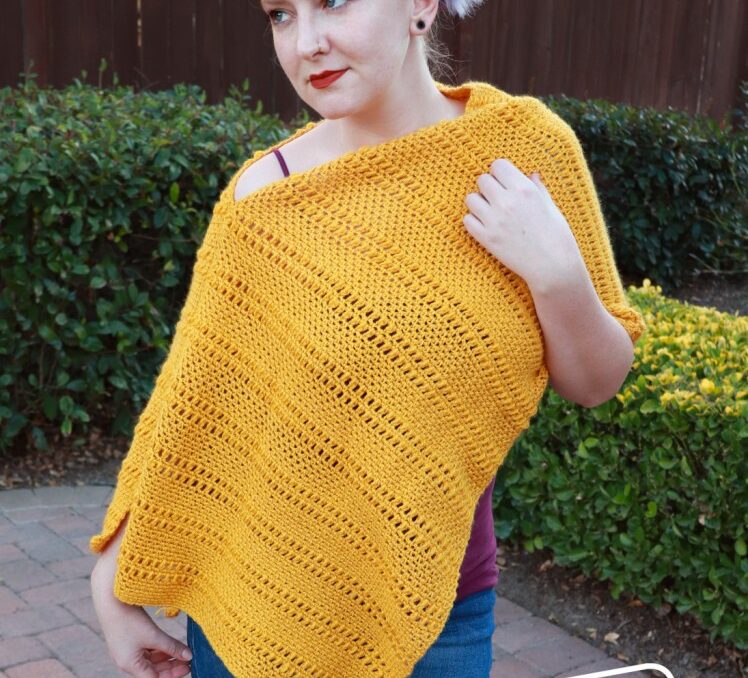 Woman wearing a yellow crochet poncho. 