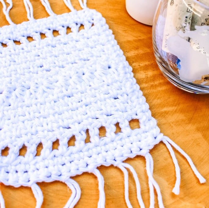 Crochet mug rug made with white yarn.