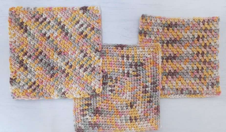 3 moss stitch crochet dishcloths on a table