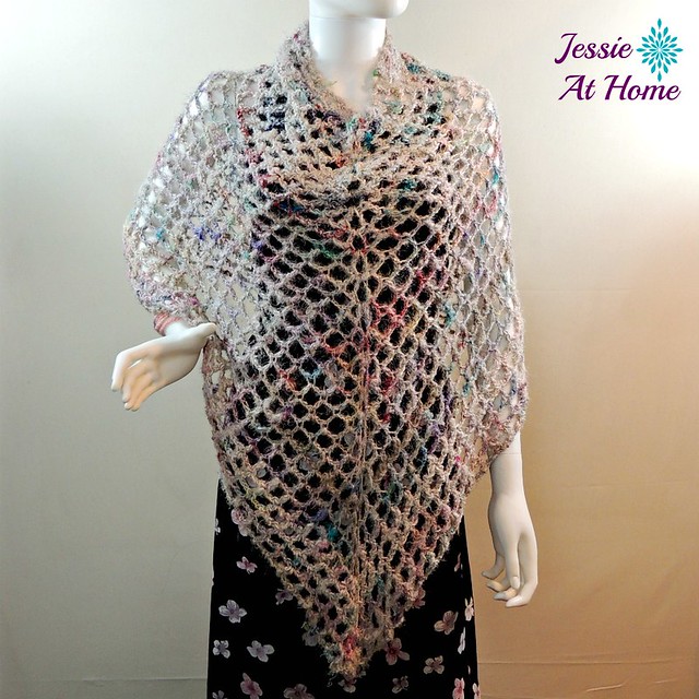 A colorful mesh crochet poncho displayed on a mannequin. 