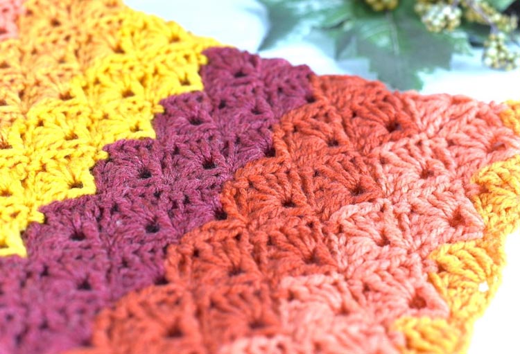 Close up of colorful striped shell stitch crochet cowl. 