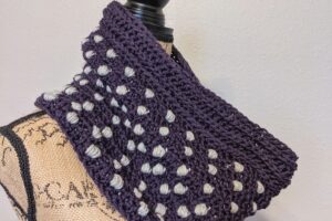 Side view of the polka dot puffs crochet cowl pattern on a mannequin