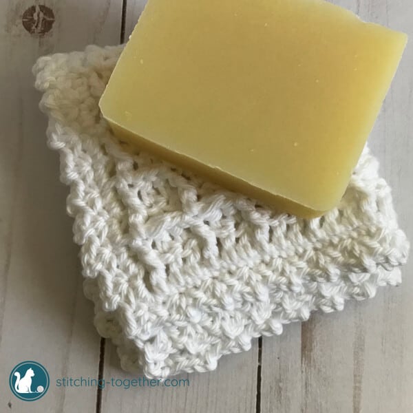 a bar of soap on top of a folded crochet washcloth