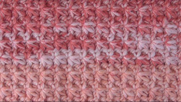 Closeup of the crochet trinity stitch washcloth worked in a fun marled pink yarn