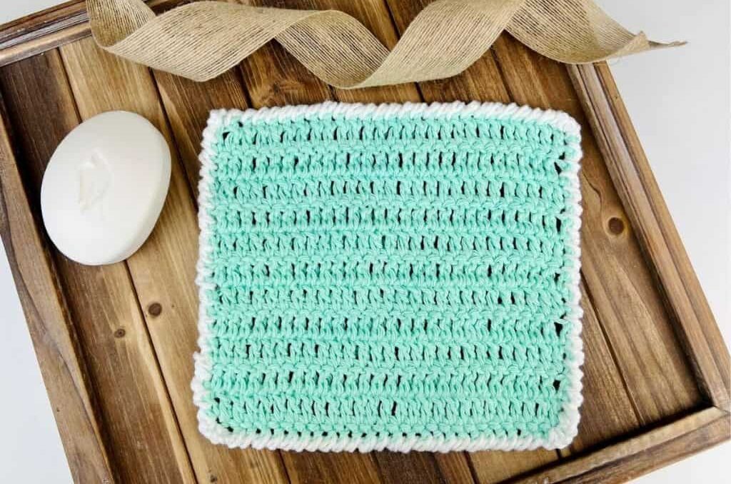 a green crochet dishcloth pattern on a tray with a bar of dove soap
