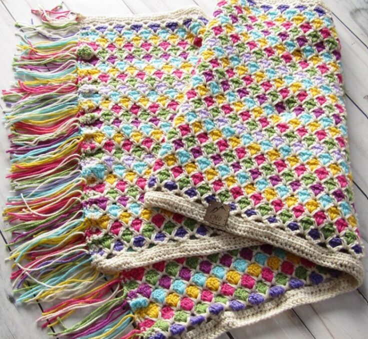 a crochet striped blanket with fun rainbow colors