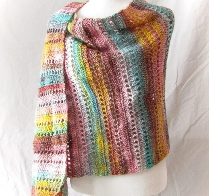 a striped crochet shawl wrapped on a white mannequin