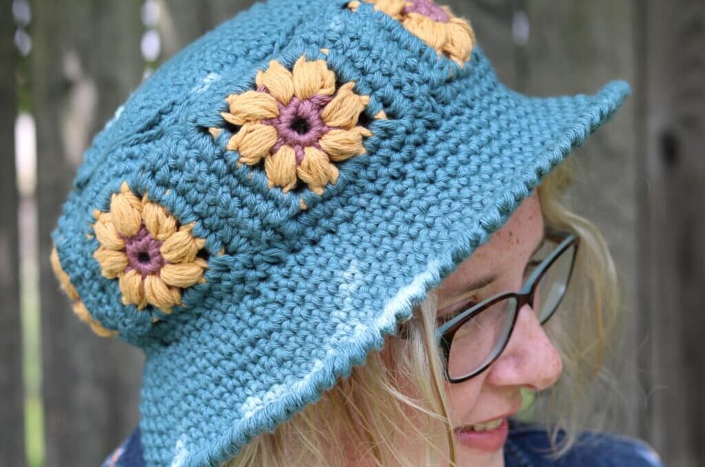 Woman wearing a flower motif crochet bucket hat. 