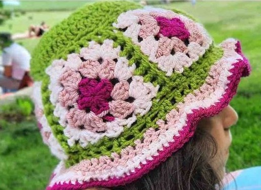 Young girl wearing a granny square crochet bucket hat. 