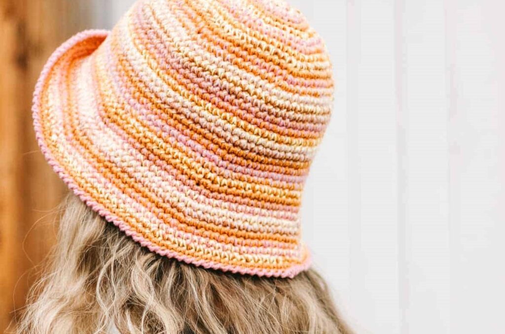 Woman wearing colorful crochet bucket hat.