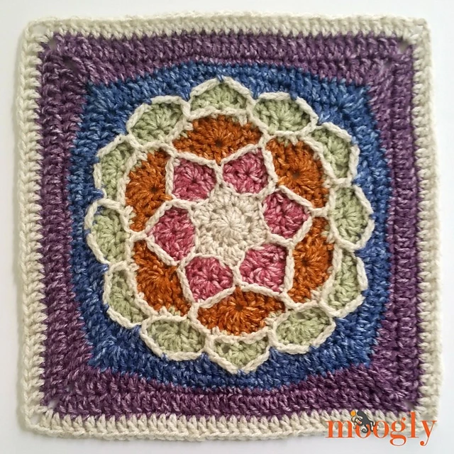 A colorful crocheted flower motif afghan square on white background. 