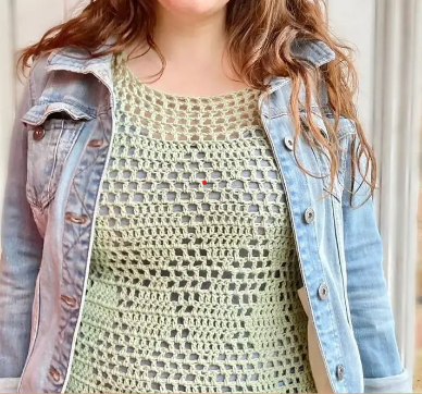 Woman wearing green crocheted tank top with a jean jacket. 