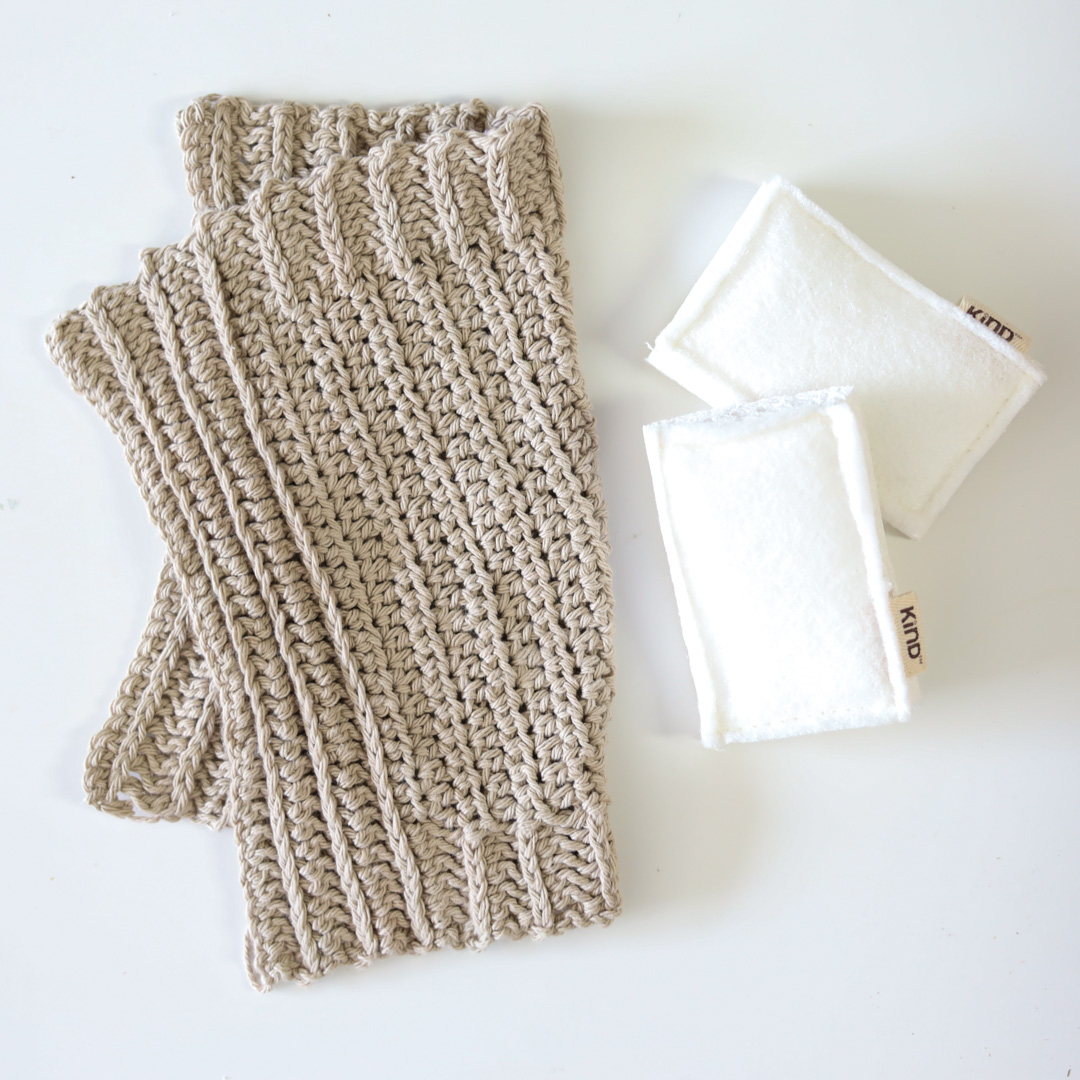 the simple ribbed dishcloth folded and laid flat beside some kitchen sponges