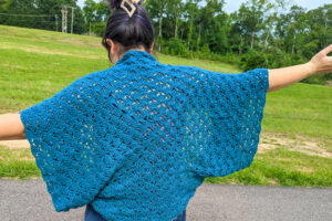 the back view of a crochet cocoon cardigan made with teal yarn