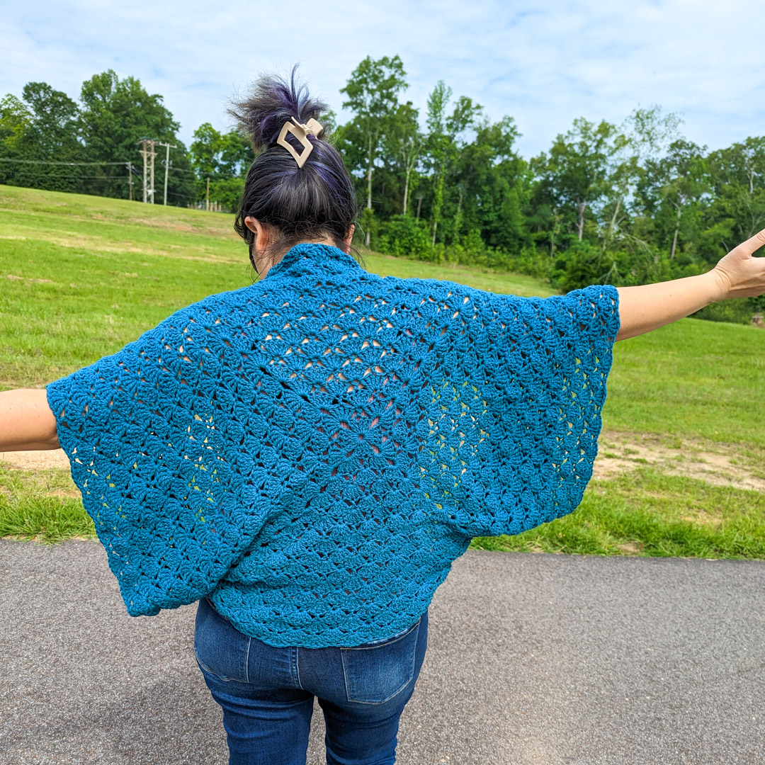 the back view of a crochet cocoon cardigan made with teal yarn