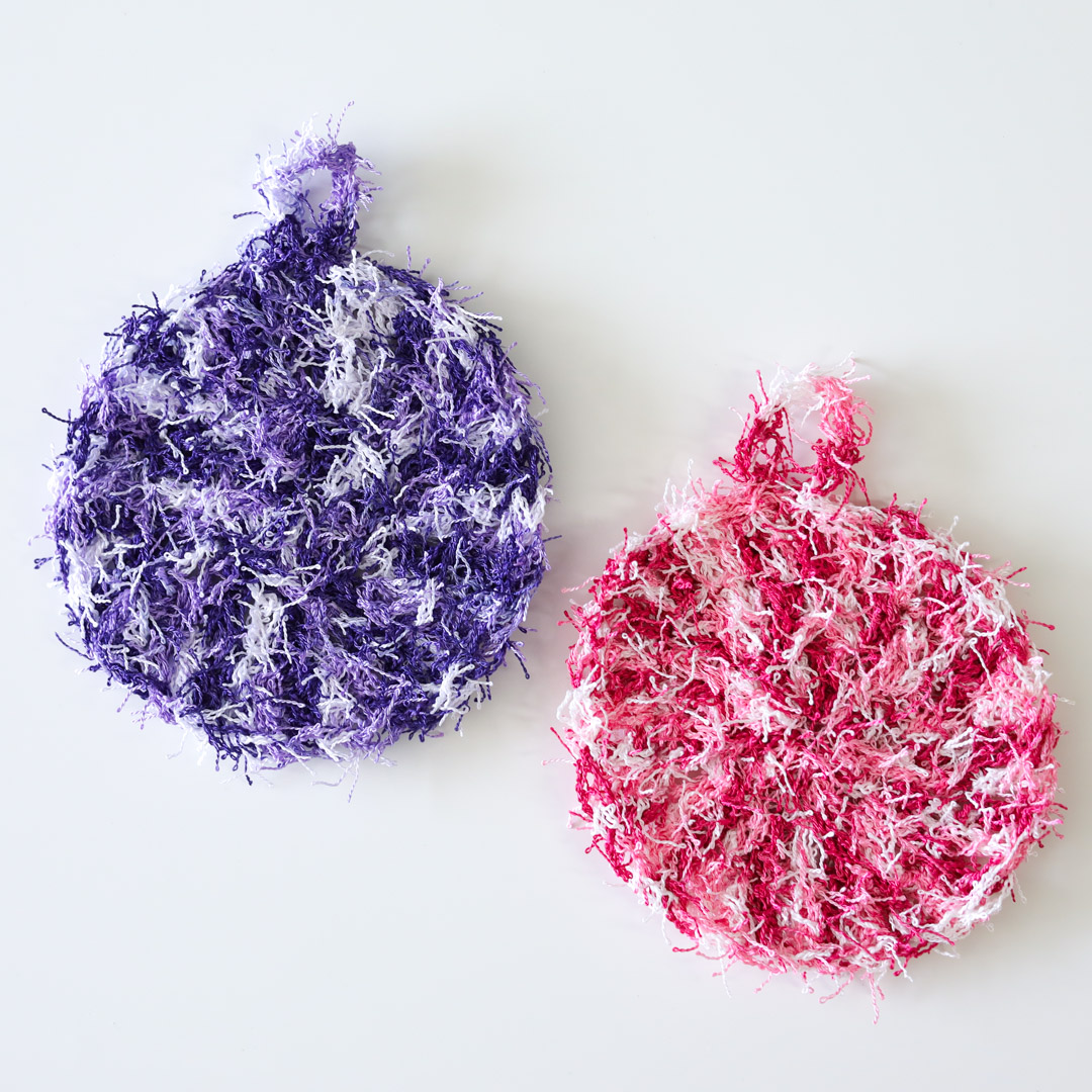 two scrubbies made with a free dish scrubby crochet pattern