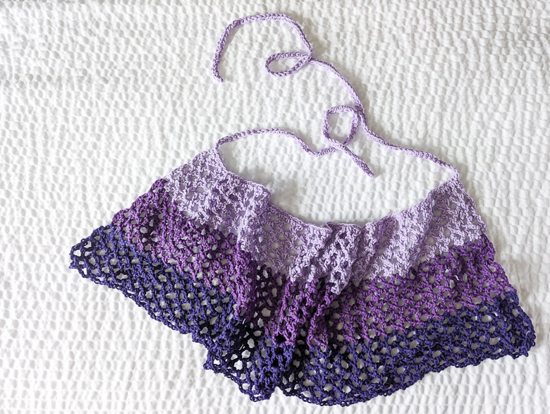 an ombre crochet sarong skirt laid flat on a white bed