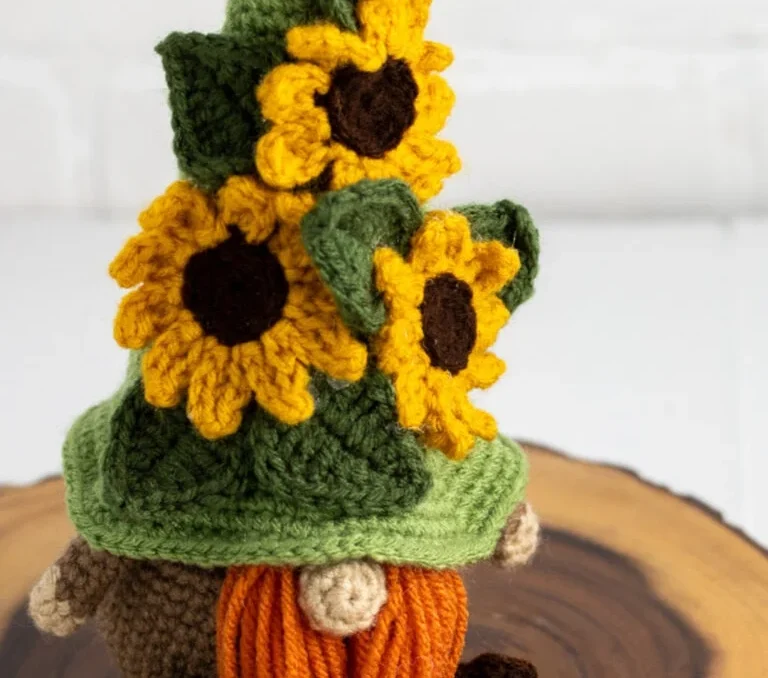 A crochet gnome with a crochet sunflower hat.